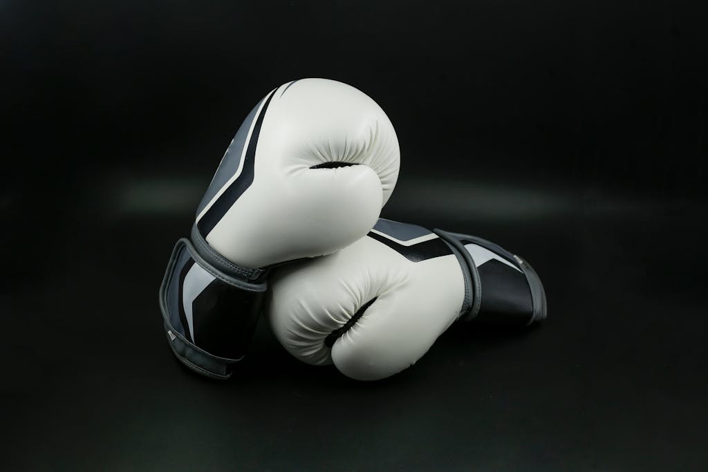 Close-up of black and white boxing gloves on a dark background, perfect for sports themes.
